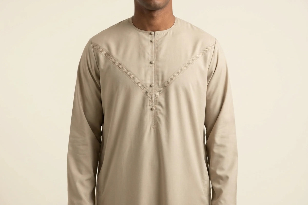Qamis émirati beige porté, encolure ronde sans col et galon tressé en V sur la poitrine