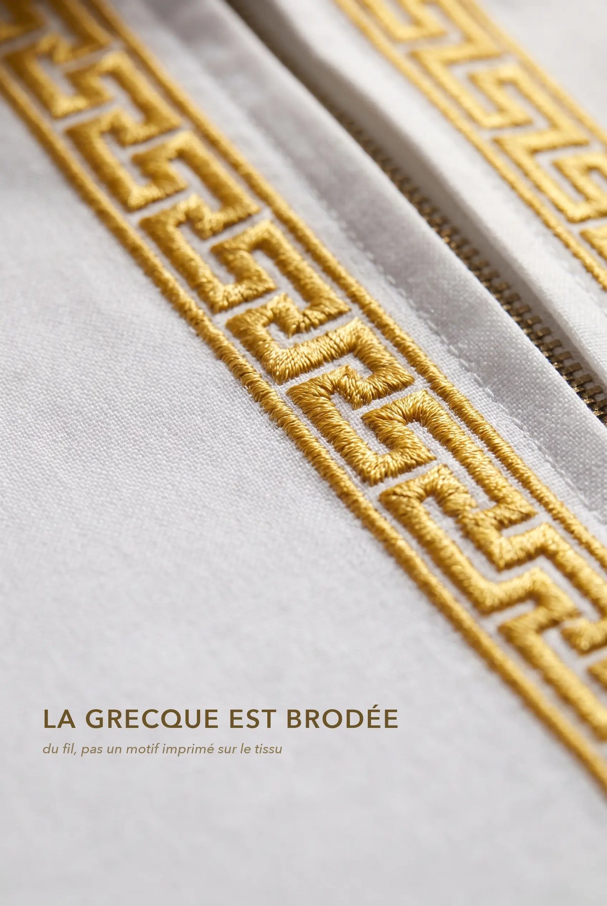 Macro de la broderie grecque dorée du qamis Mehdi blanc, fil brodé en relief