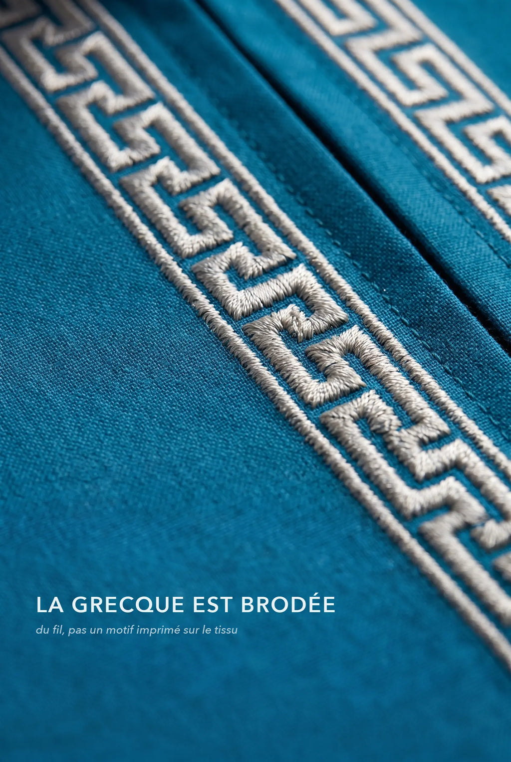 Macro de la broderie grecque argentée du qamis Mehdi bleu canard, fil brodé en relief
