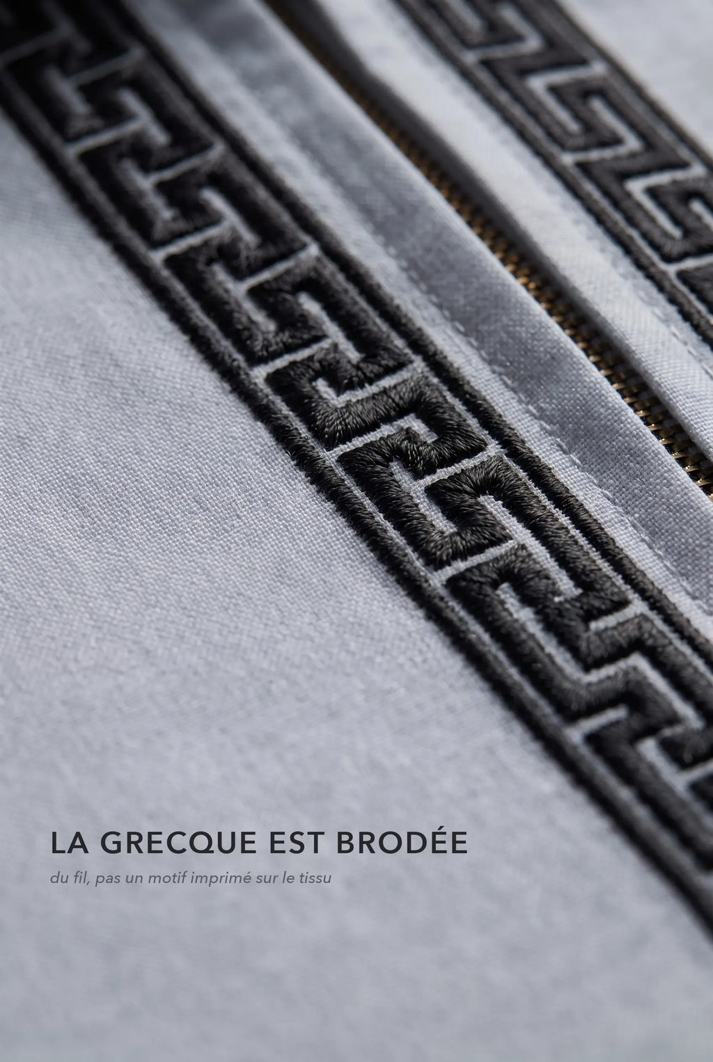Macro de la broderie grecque noire du qamis Mehdi gris, fil brodé en relief