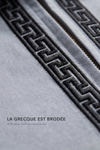 Macro de la broderie grecque noire du qamis Mehdi gris, fil brodé en relief