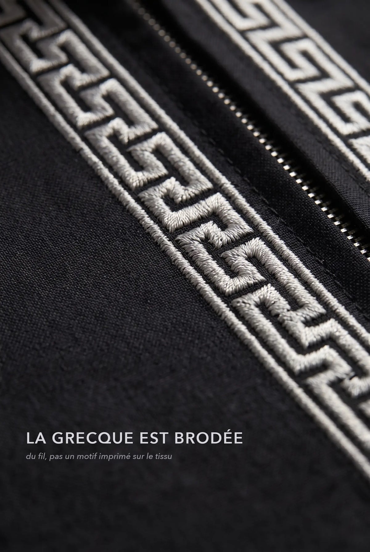 Macro de la broderie grecque argentée du qamis Mehdi noir, fil brodé en relief