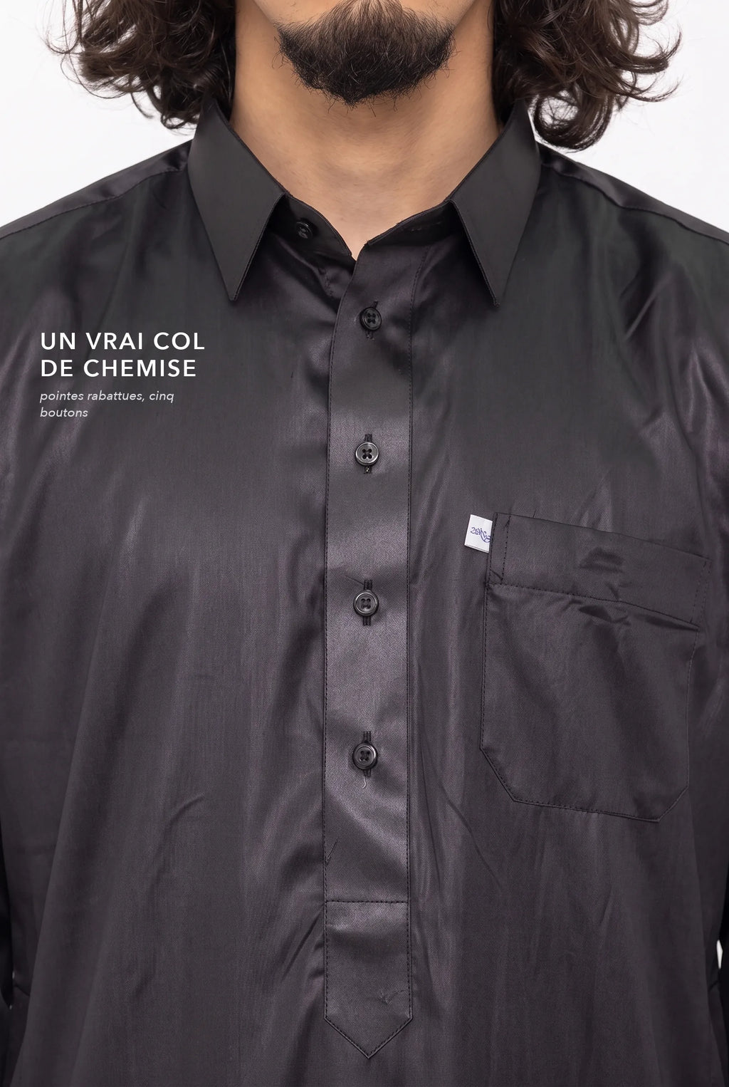 Col de chemise et patte boutonnée du qamis qatari Khalid noir, macro