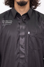 Col de chemise et patte boutonnée du qamis qatari Khalid noir, macro