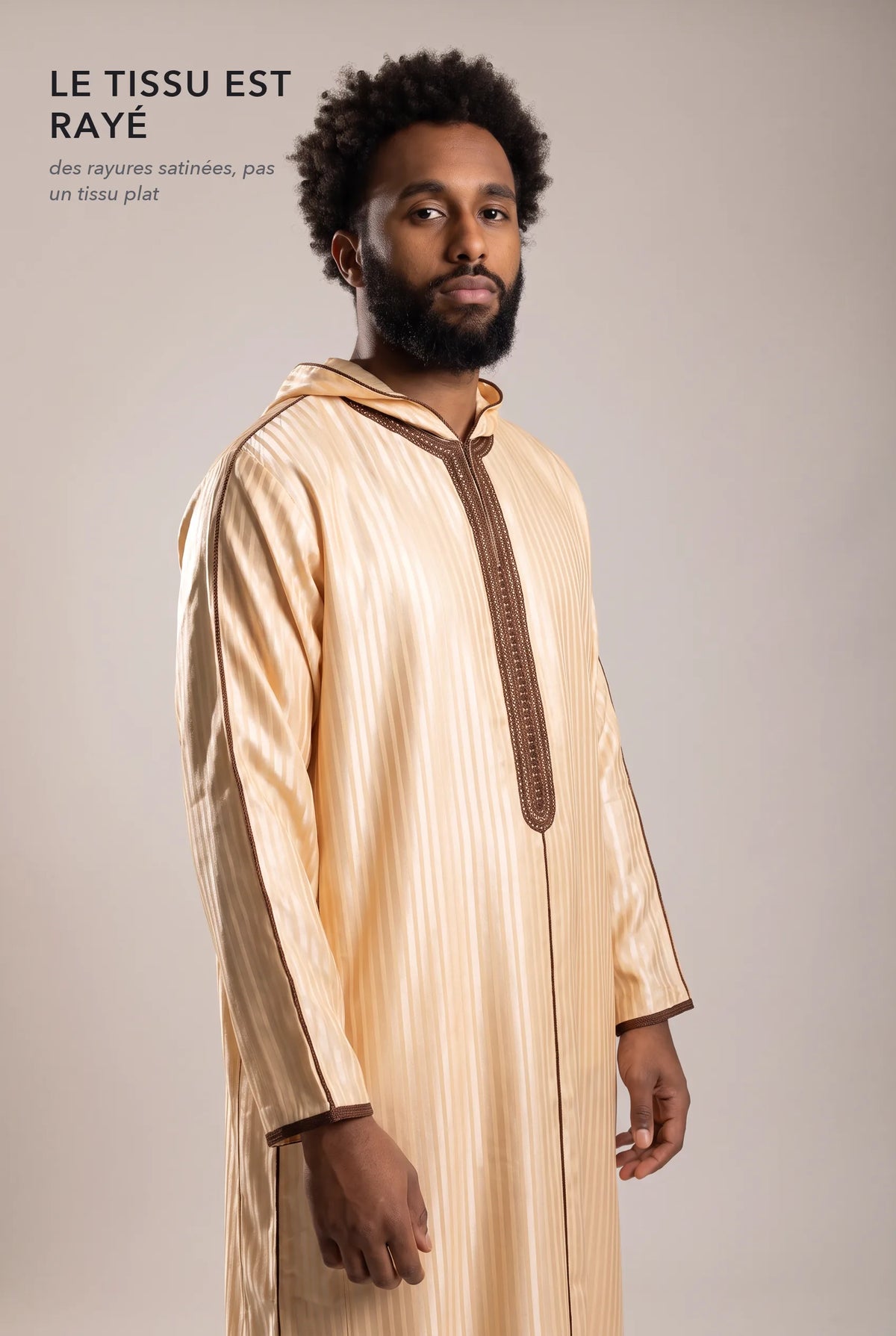 Tissu satin rayé ton sur ton de la djellaba Fares beige en lumière rasante
