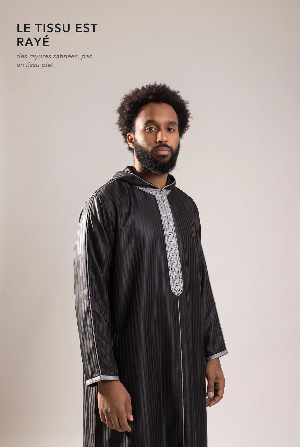 Tissu satin rayé ton sur ton de la djellaba Fares noire en lumière rasante