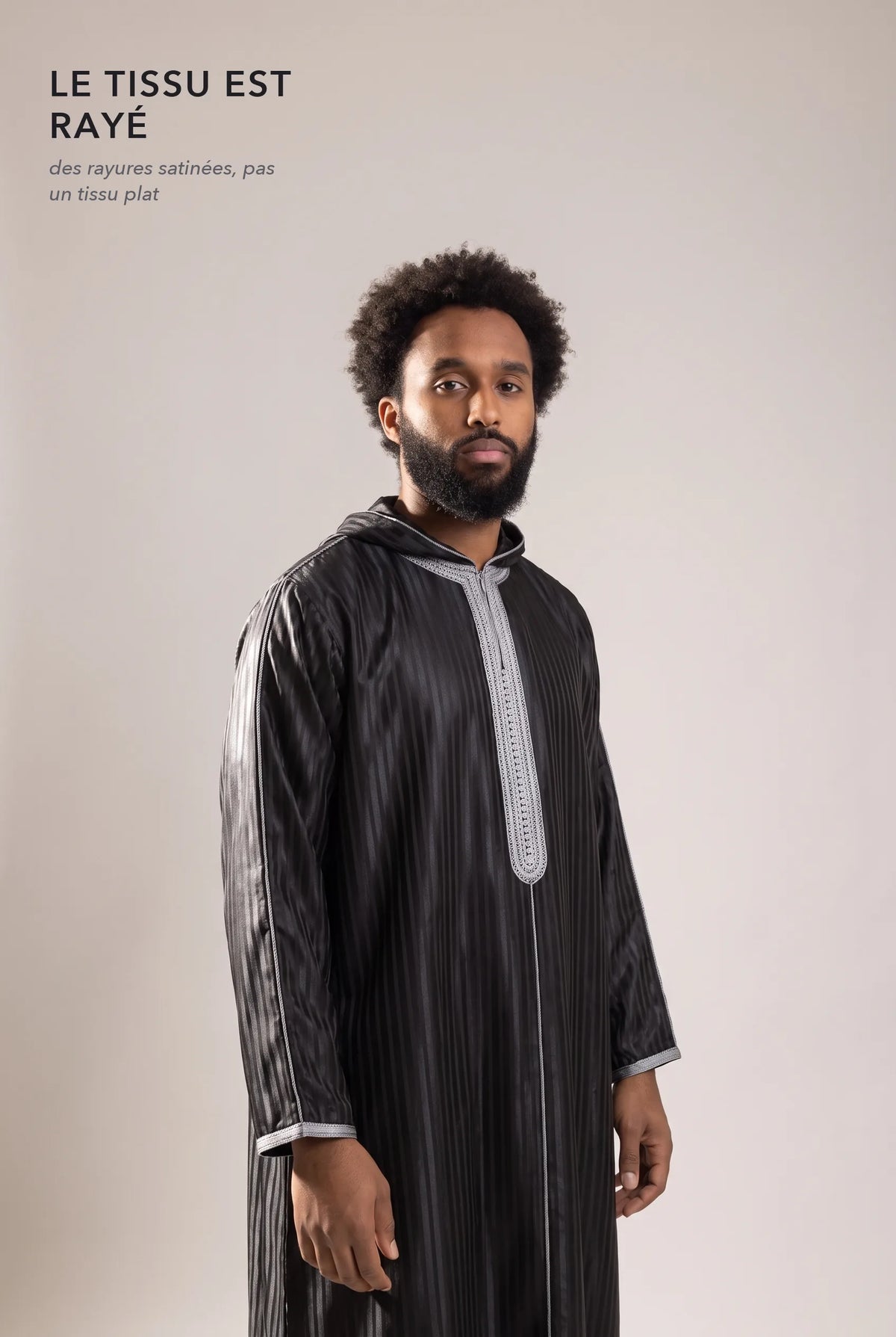 Tissu satin rayé ton sur ton de la djellaba Fares noire en lumière rasante
