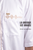 Macro sur la grecque brodée dorée et la poche poitrine