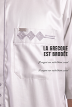Macro sur la grecque brodée argent et la poche poitrine