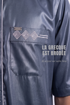 Macro sur la grecque brodée argent et la poche poitrine