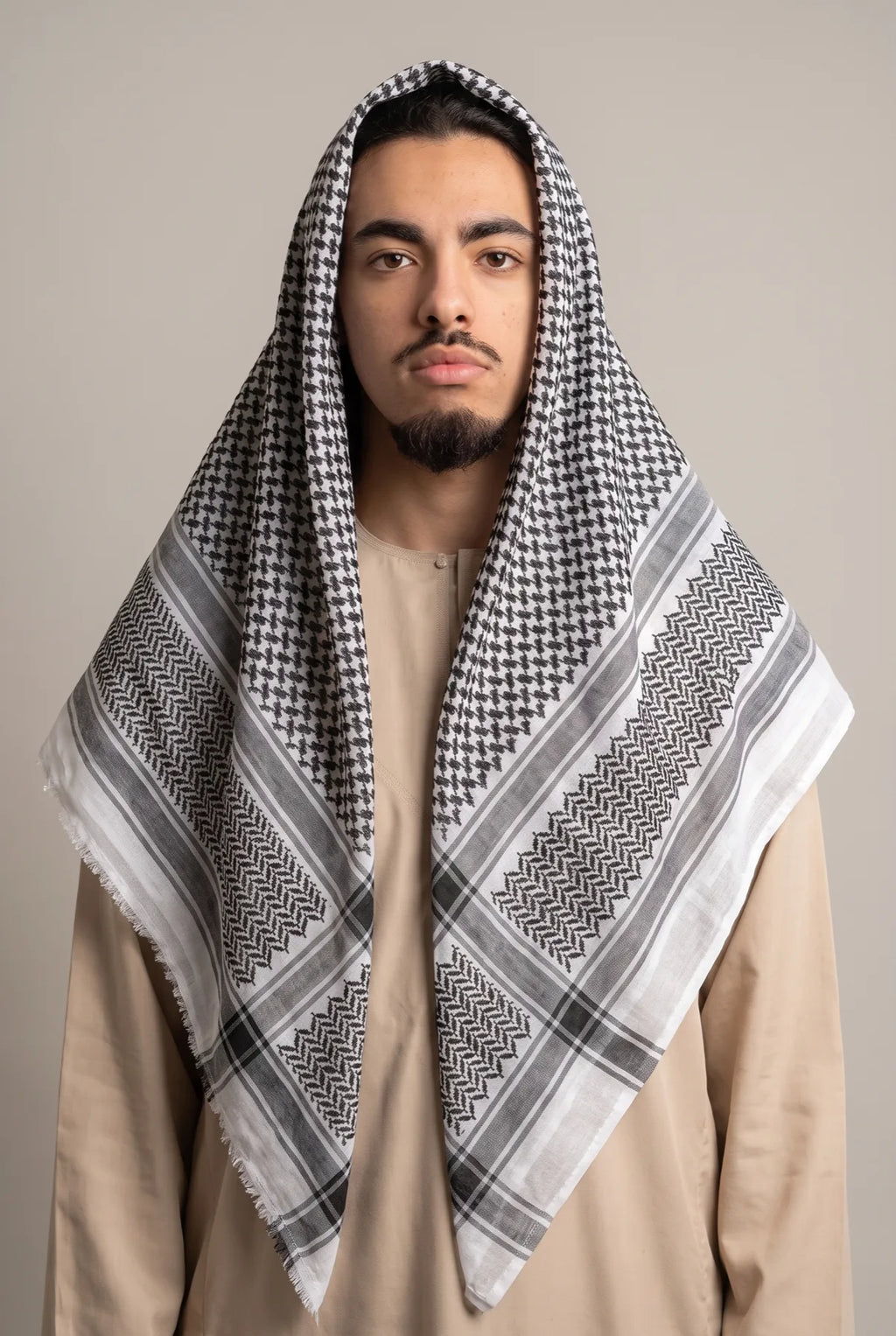 Keffieh classique noir et blanc porté sur la tête, motif filet et chevrons