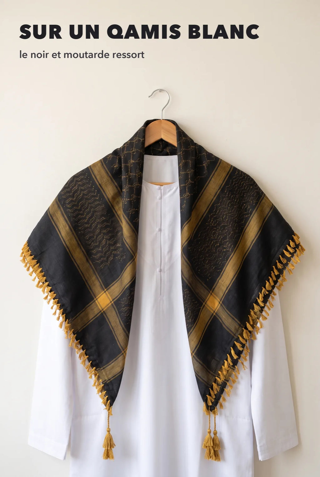 Keffieh luxe noir et or posé sur un qamis blanc