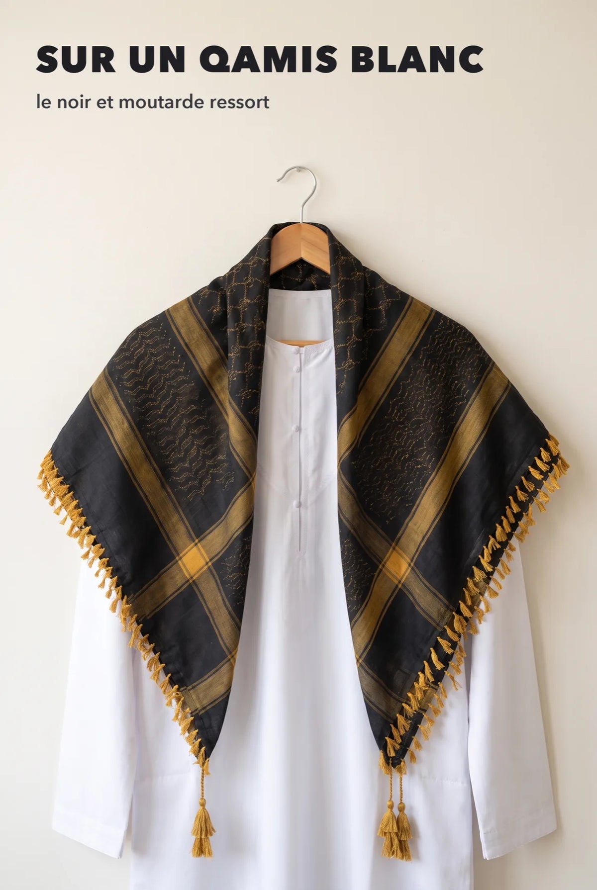 Keffieh luxe noir et or posé sur un qamis blanc