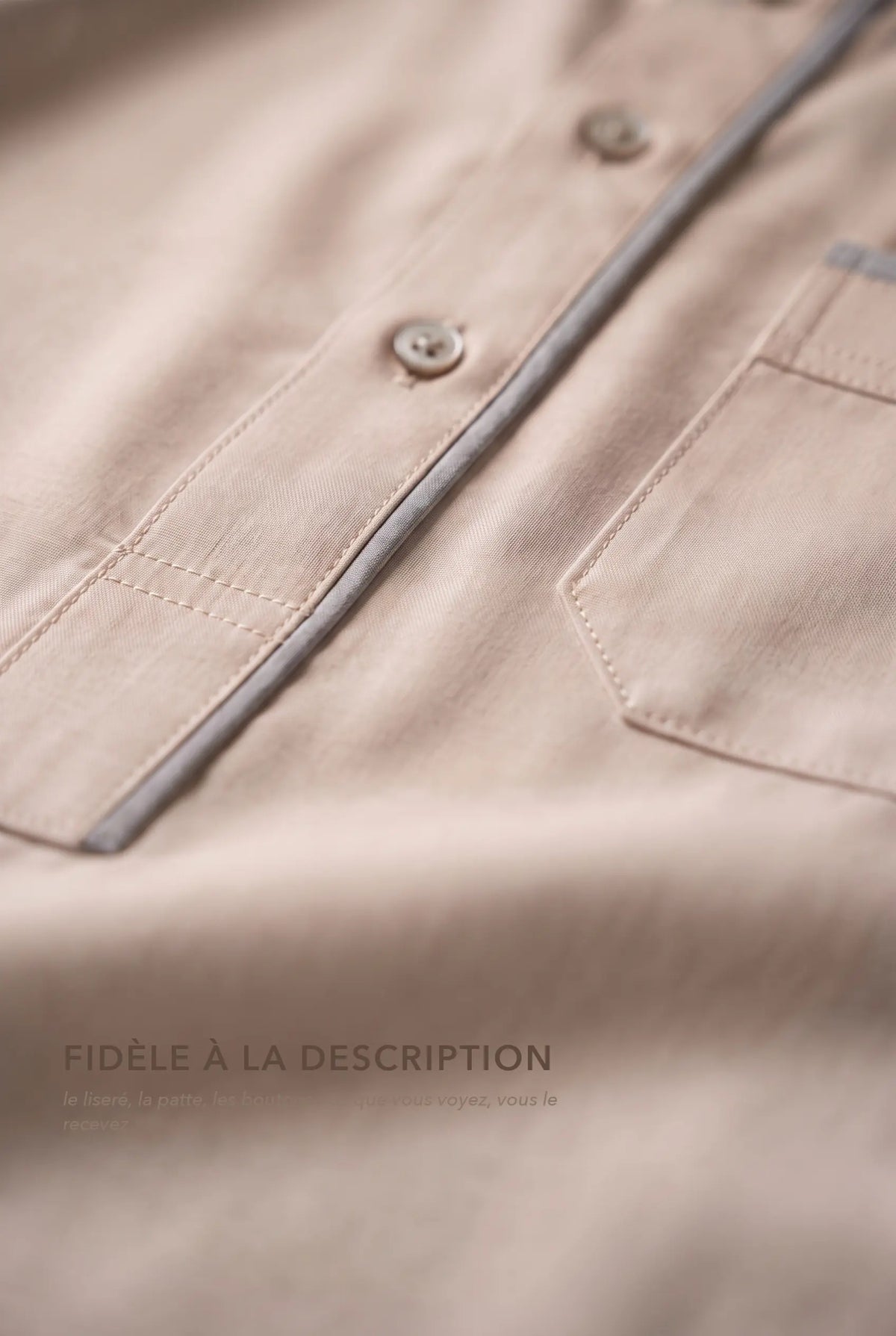 Macro du liséré gris et des boutons du qamis Issa beige, fidèle à la description