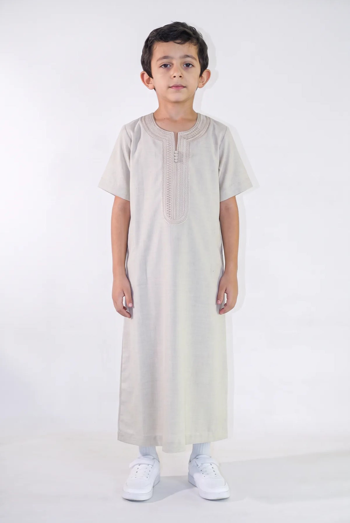 Qamis enfant Anas beige porté de face, manches courtes et plastron brodé