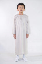 Qamis enfant Zaid beige satiné porté de face, émirati brodé ton sur ton