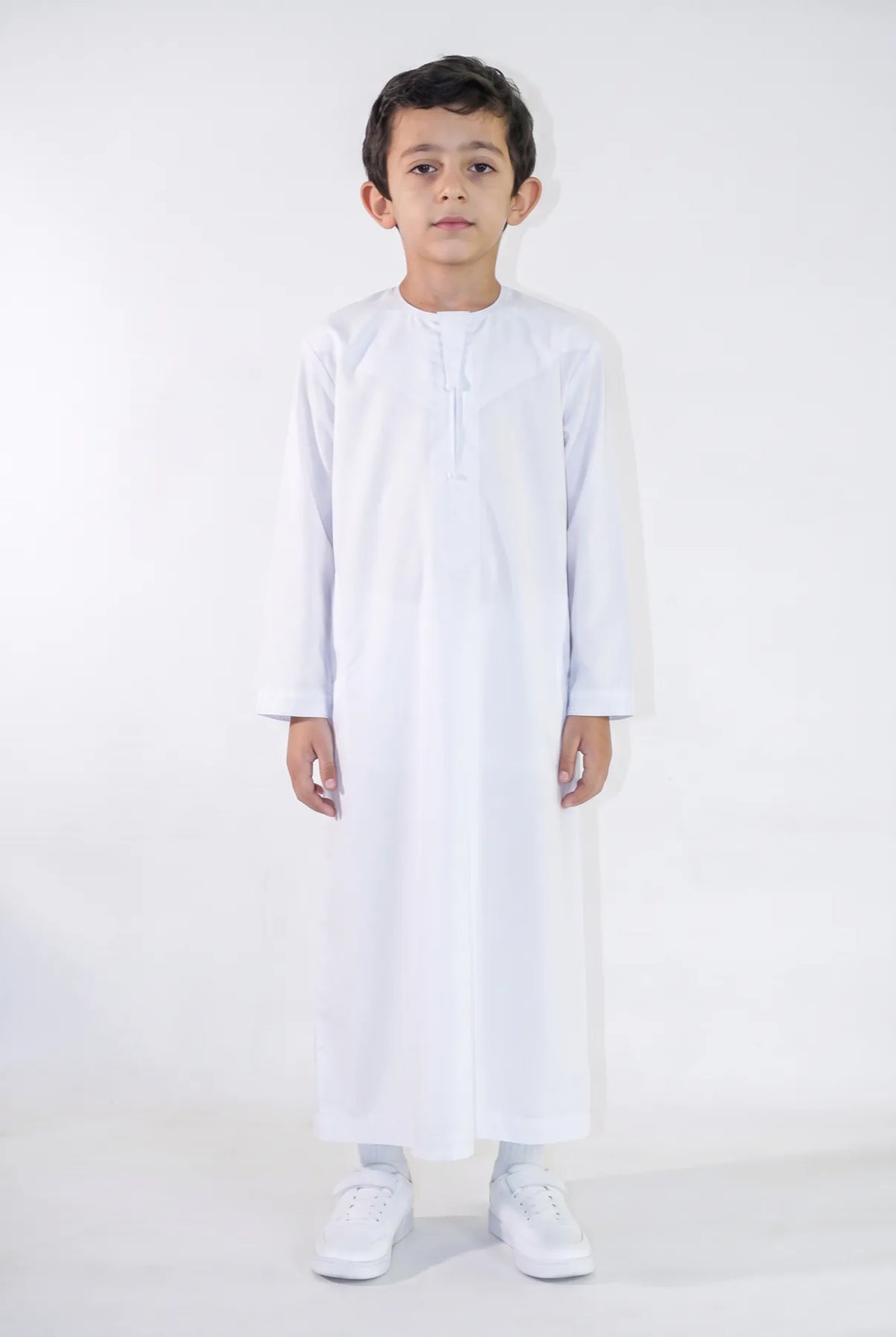 Qamis enfant Zaid blanc satiné porté de face, émirati brodé ton sur ton