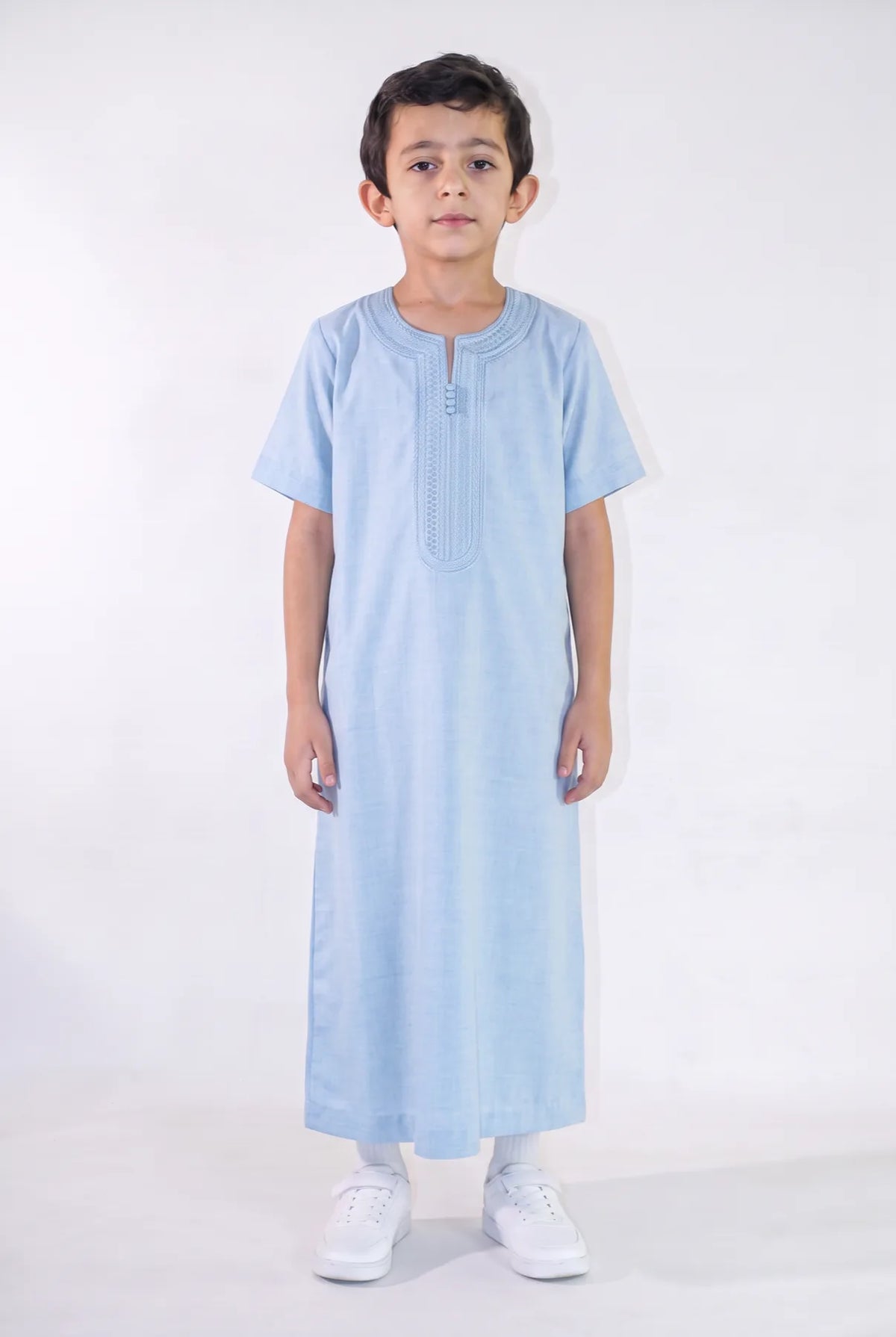 Qamis enfant Anas bleu porté de face, manches courtes et plastron brodé