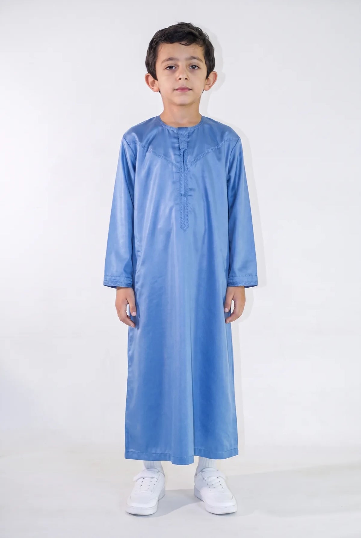 Qamis enfant Zaid bleu satiné porté de face, émirati brodé ton sur ton