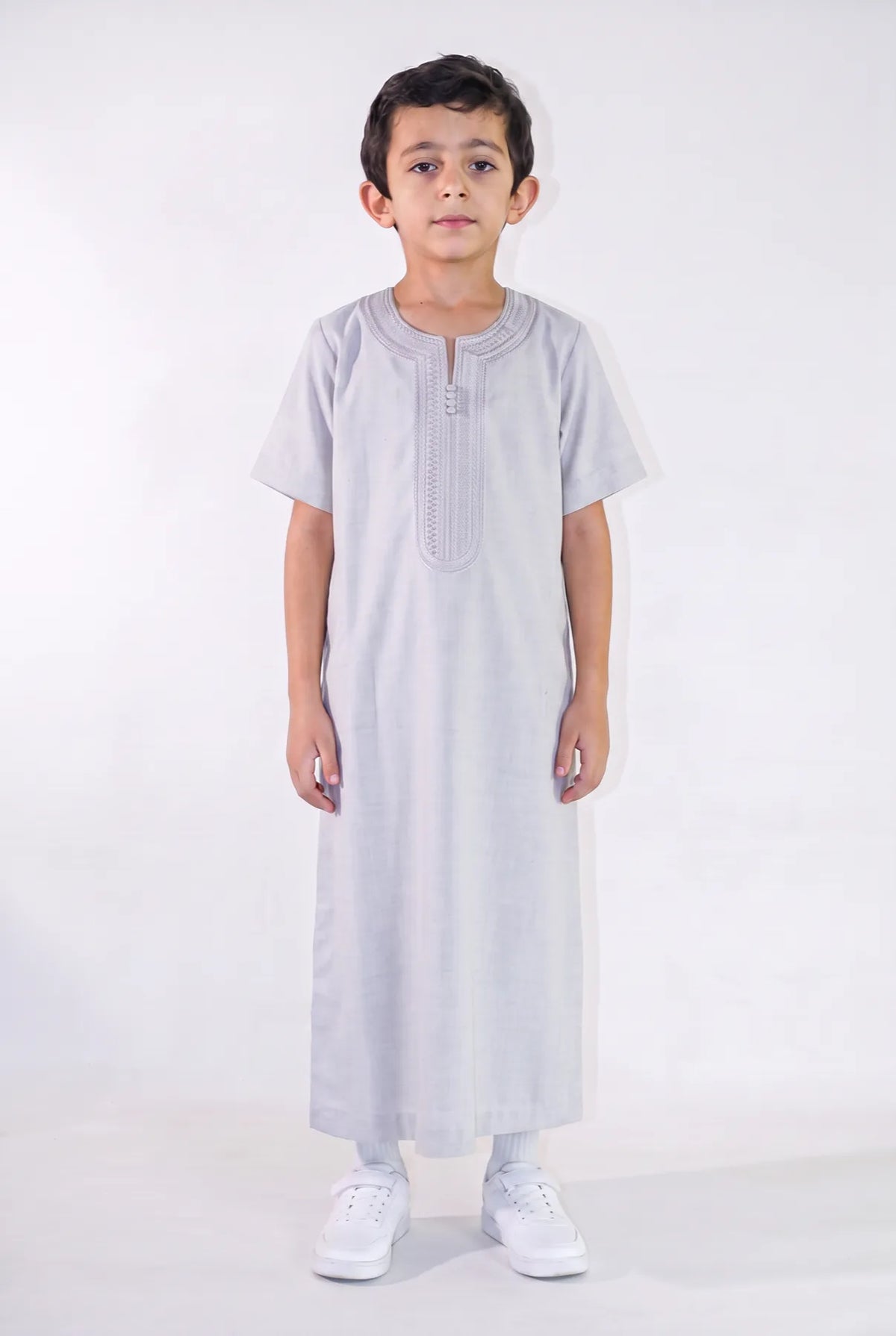 Qamis enfant Anas gris porté de face, manches courtes et plastron brodé