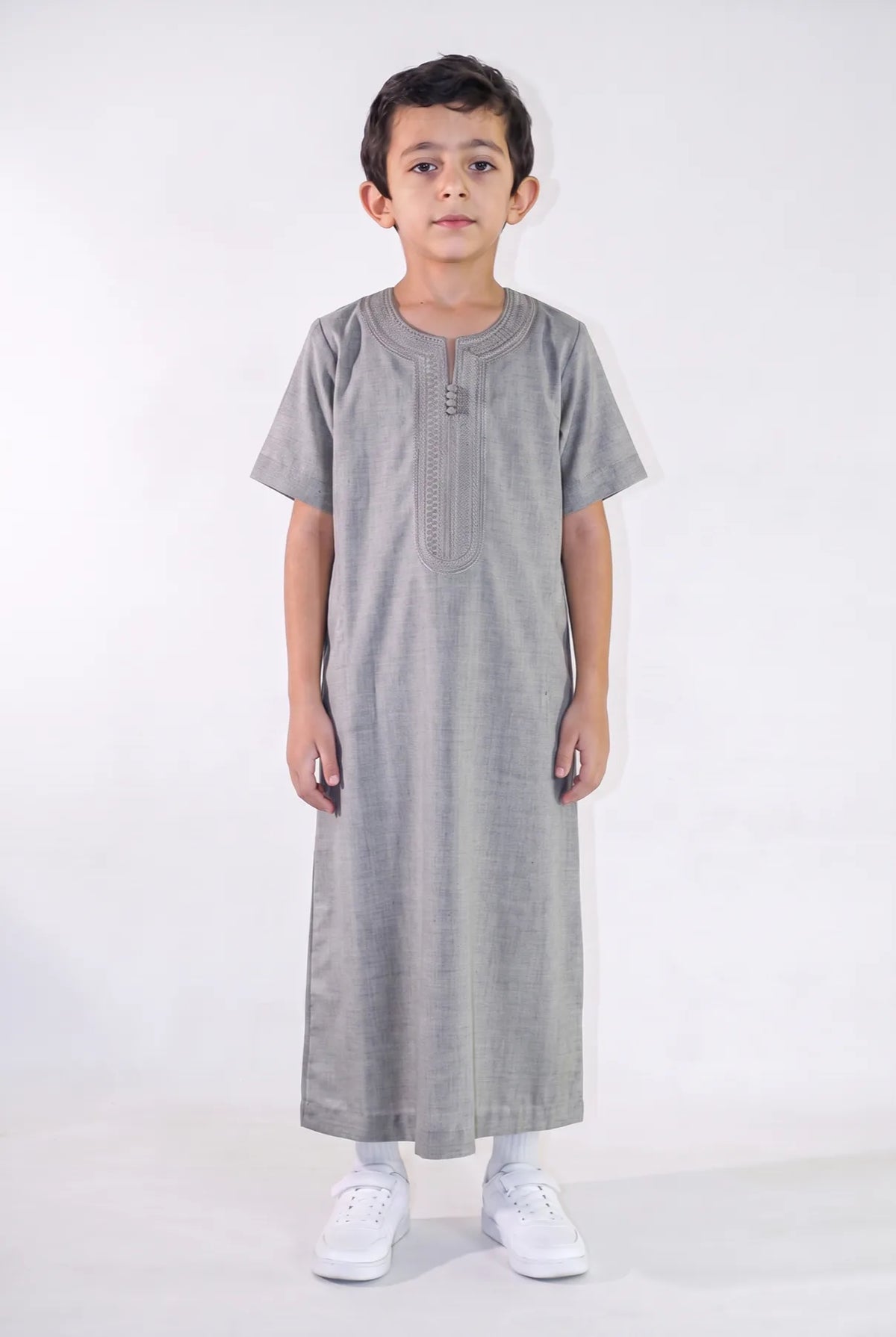 Qamis enfant Anas gris foncé porté de face, manches courtes et plastron brodé