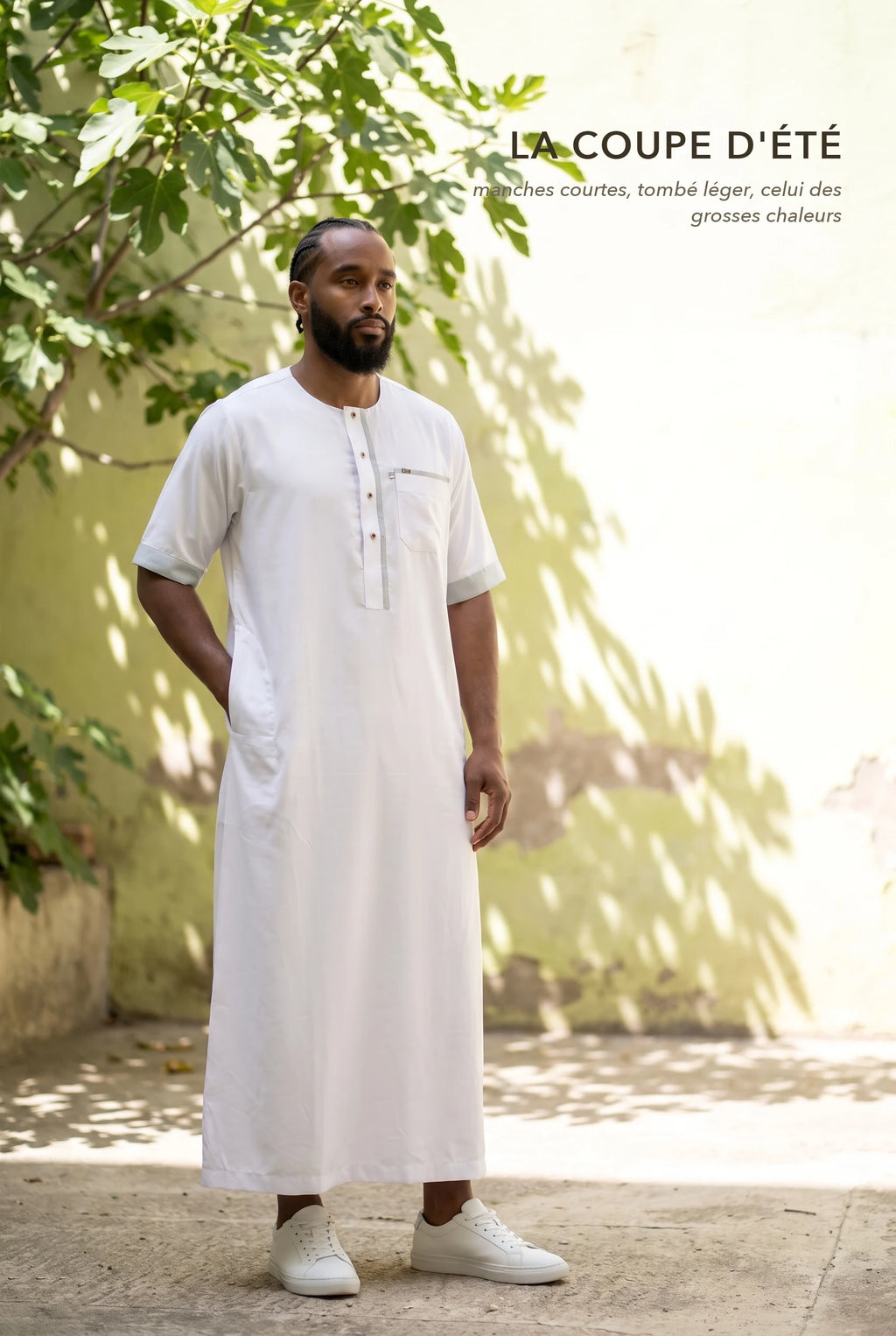 Qamis Issa blanc porté dans une cour ensoleillée, la coupe d'été à manches courtes