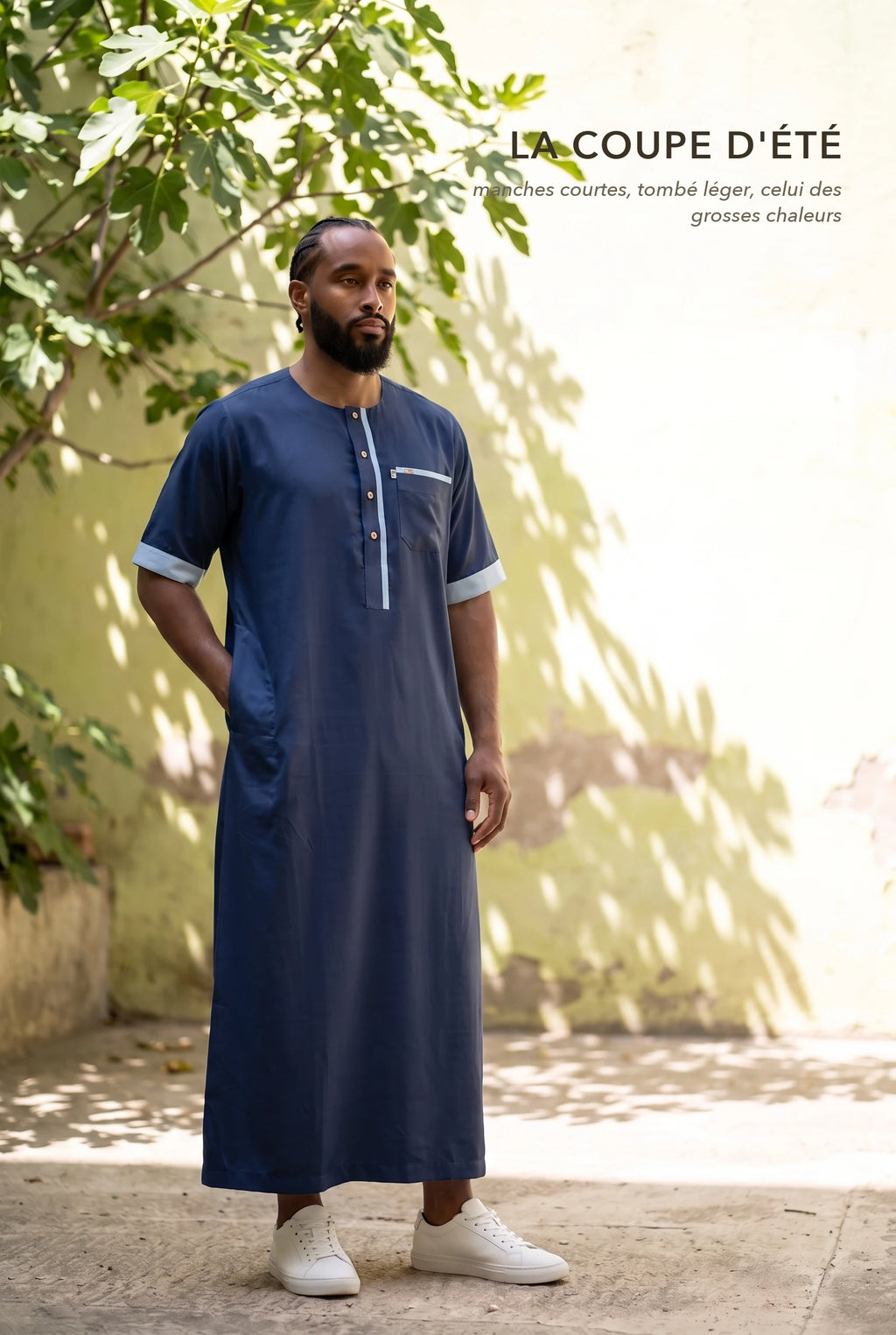 Qamis Issa bleu marine porté dans une cour ensoleillée, la coupe d'été à manches courtes