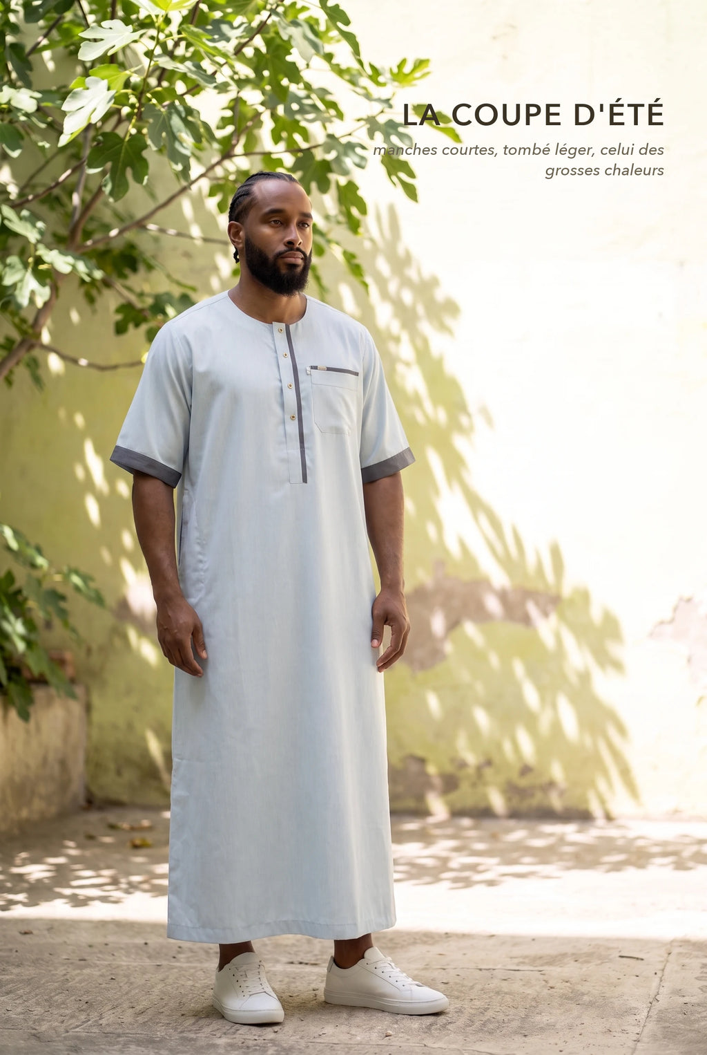 Qamis Issa bleu pastel porté dans une cour ensoleillée, la coupe d'été à manches courtes