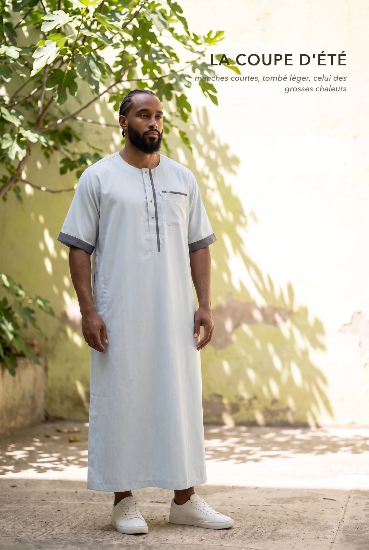 Qamis Issa bleu pastel porté dans une cour ensoleillée, la coupe d'été à manches courtes