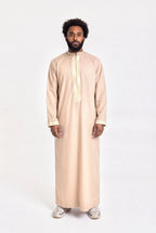 Qamis moderne beige Mehdi porté de face, plastron brodé d'une grecque dorée et col mao