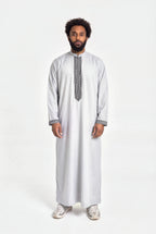 Qamis moderne gris Mehdi porté de face, plastron brodé d'une grecque noire et col mao