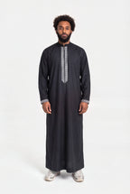 Qamis moderne noir Mehdi porté de face, plastron brodé d'une grecque argentée et col mao