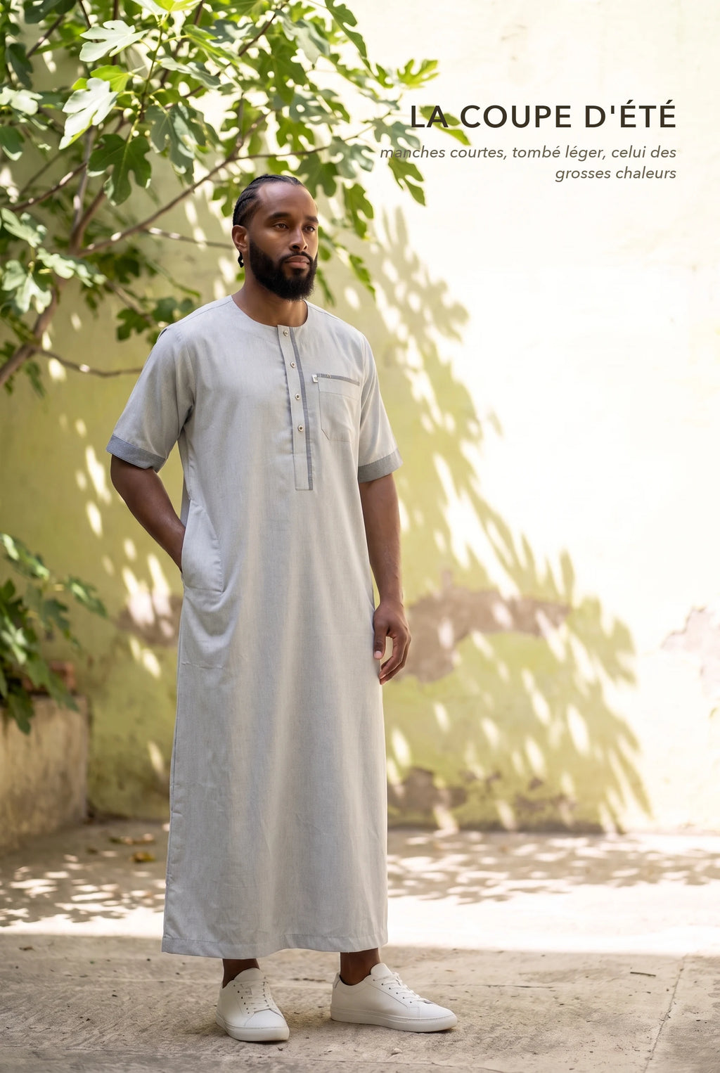 Qamis Issa gris porté dans une cour ensoleillée, la coupe d'été à manches courtes