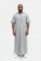 Qamis moderne gris Issa porté de face, manches courtes à revers et liséré sur la patte et la poche