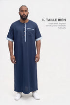 Qamis Issa bleu marine en pied, coupe droite longueur cheville, il taille bien