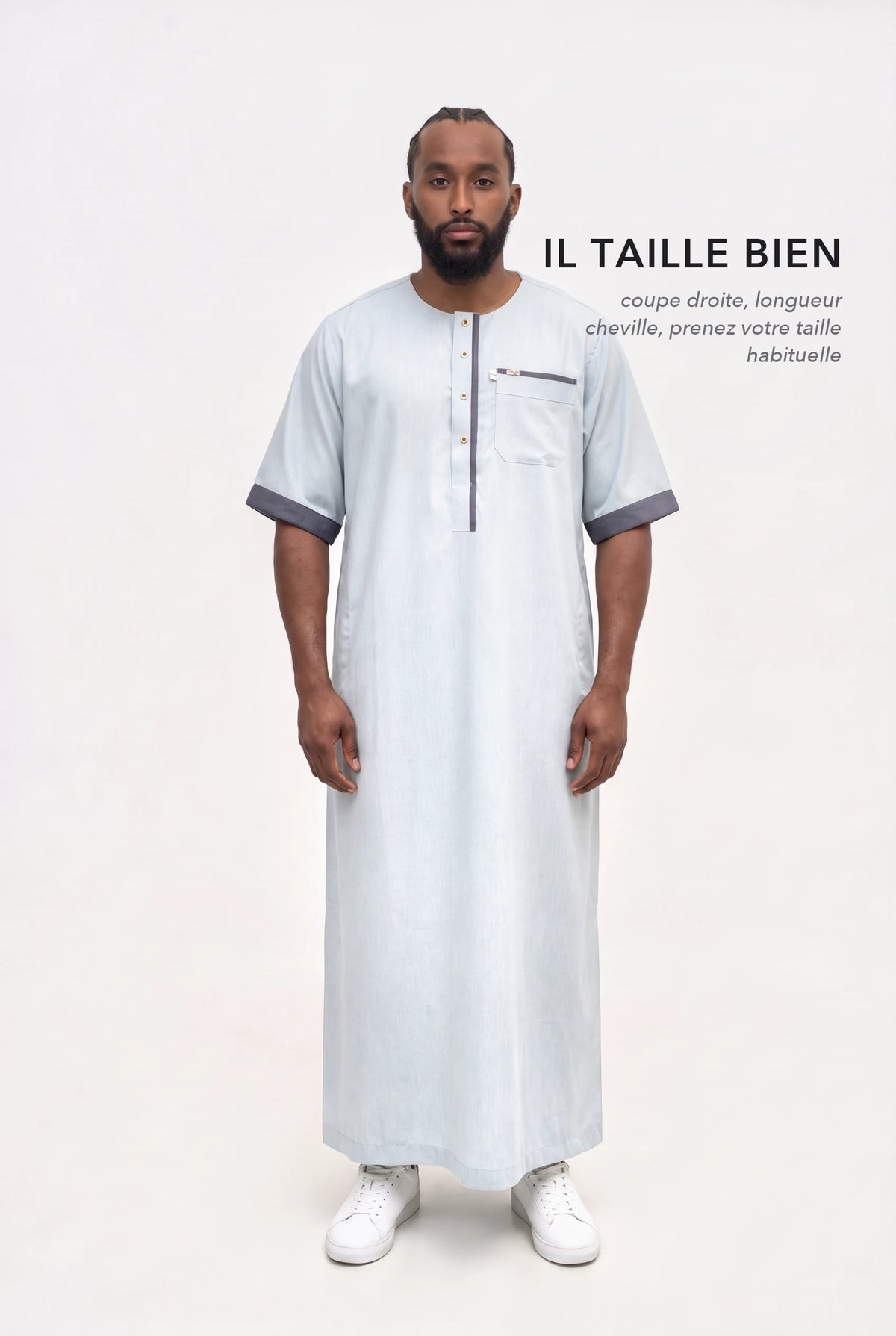 Qamis Issa bleu pastel en pied, coupe droite longueur cheville, il taille bien