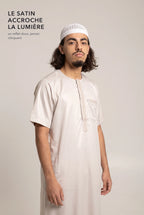 Le satin du qamis Nabil blanc cassé accroche la lumière