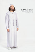 Qamis omani Hamza gris en pied, coupe droite et fluide longueur cheville, il taille bien