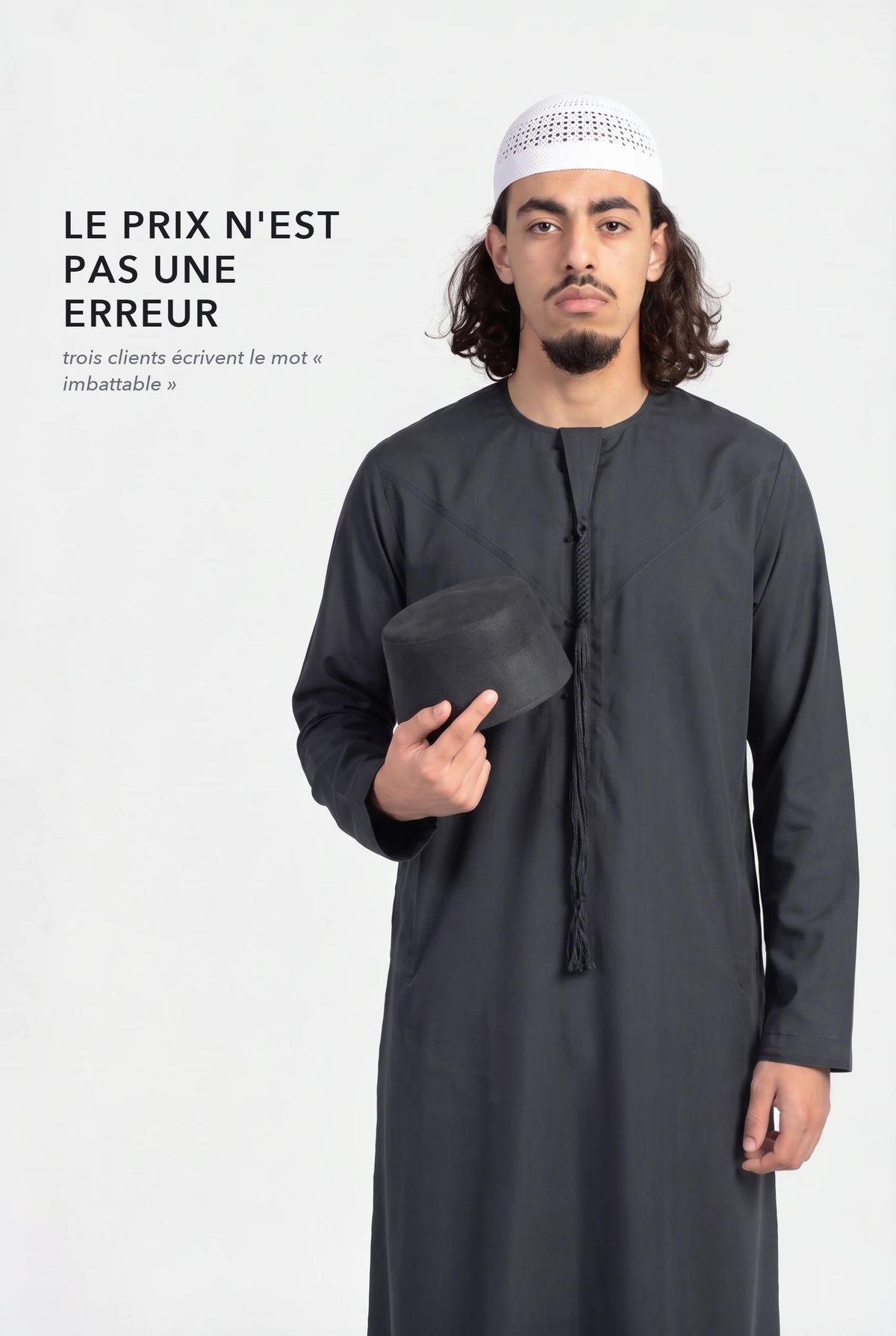 Qamis omani Hamza noir, la tarboucha tenue à la main, le qamis à 17,90 euros