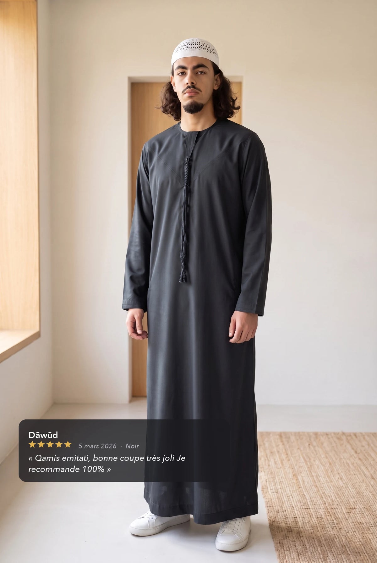 Qamis omani noir Hamza porté en intérieur, avec l'avis cinq étoiles d'un client