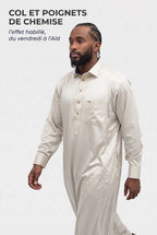 Homme en marche portant le qamis qatari satiné Adam blanc cassé, col et poignets de chemise