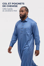 Homme en marche portant le qamis qatari satiné Adam bleu clair, col et poignets de chemise