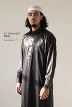 Tissu satiné du qamis qatari noir Khalid en lumière rasante
