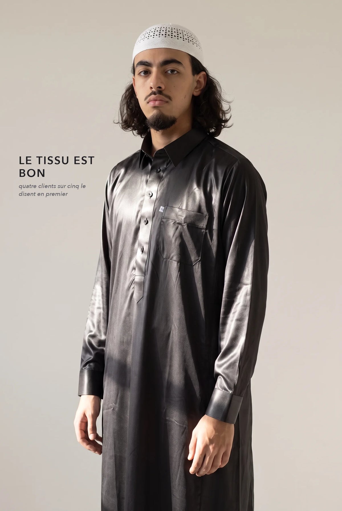 Tissu satiné du qamis qatari noir Khalid en lumière rasante
