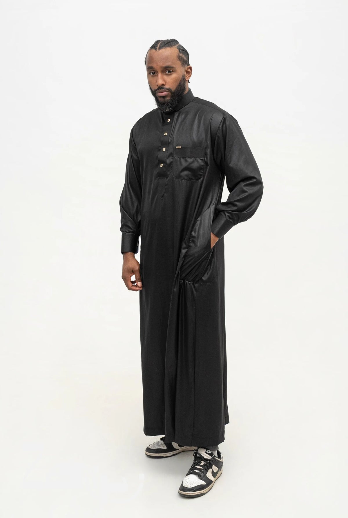 Qamis qatari satiné Adam noir porté, col de chemise et poche poitrine, sur fond blanc