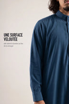 Surface veloutée du qamis Ammar bleu, le tissu retient la lumière