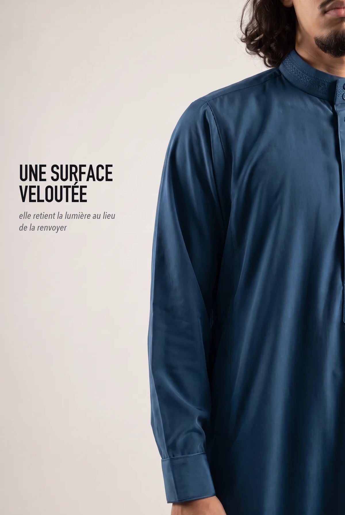 Surface veloutée du qamis Ammar bleu, le tissu retient la lumière