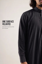 Surface veloutée du qamis Ammar noir, le tissu retient la lumière