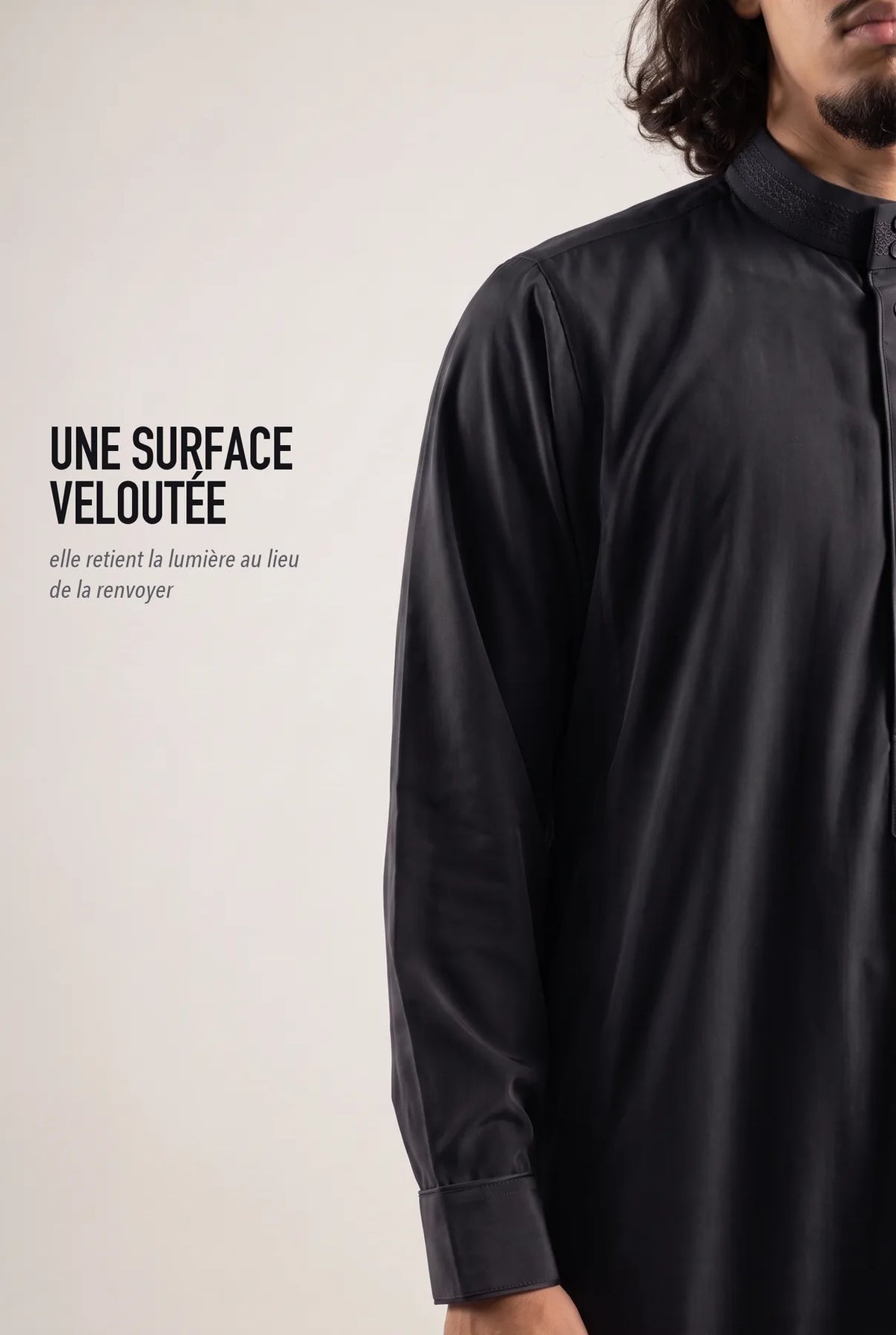 Surface veloutée du qamis Ammar noir, le tissu retient la lumière