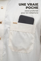 Poche poitrine du qamis Musa blanc cassé avec un téléphone glissé dedans